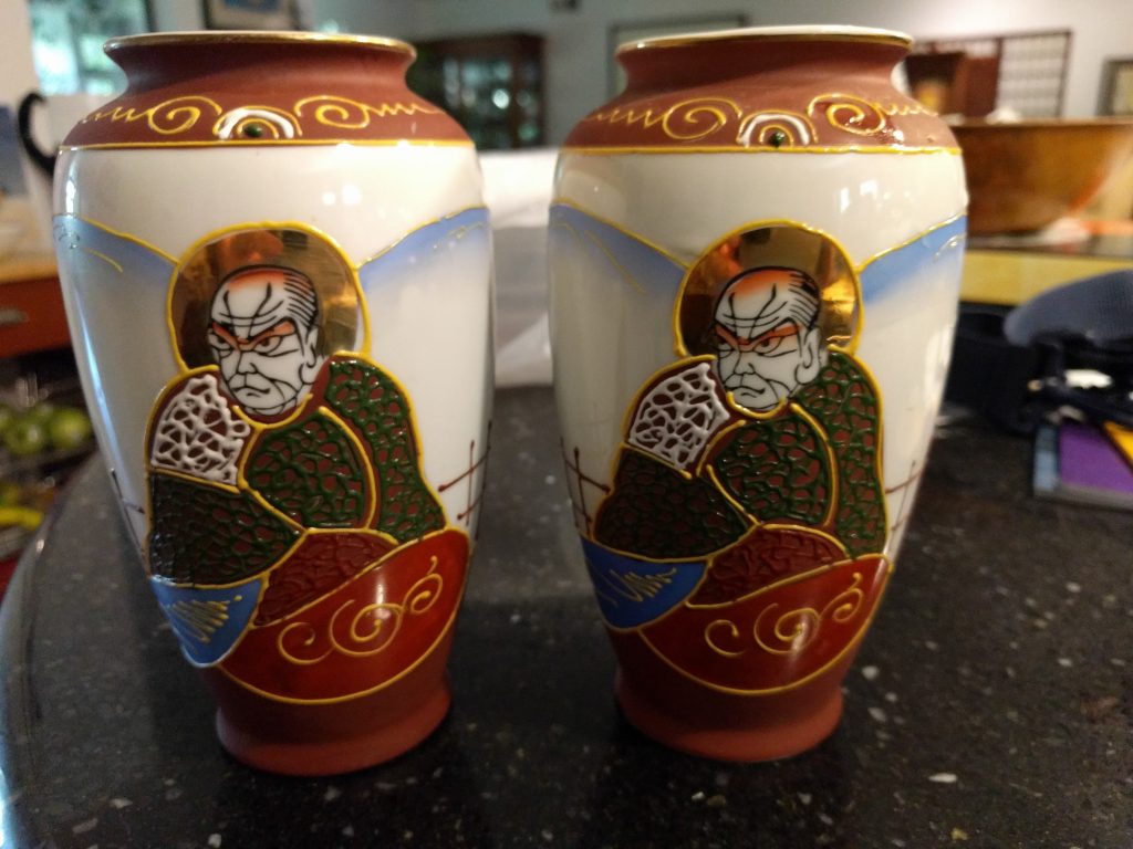 A pair of hand-painted Saint Nichiren vases. These are six inches tall and about 3.5 inches in  diameter at their widest point.